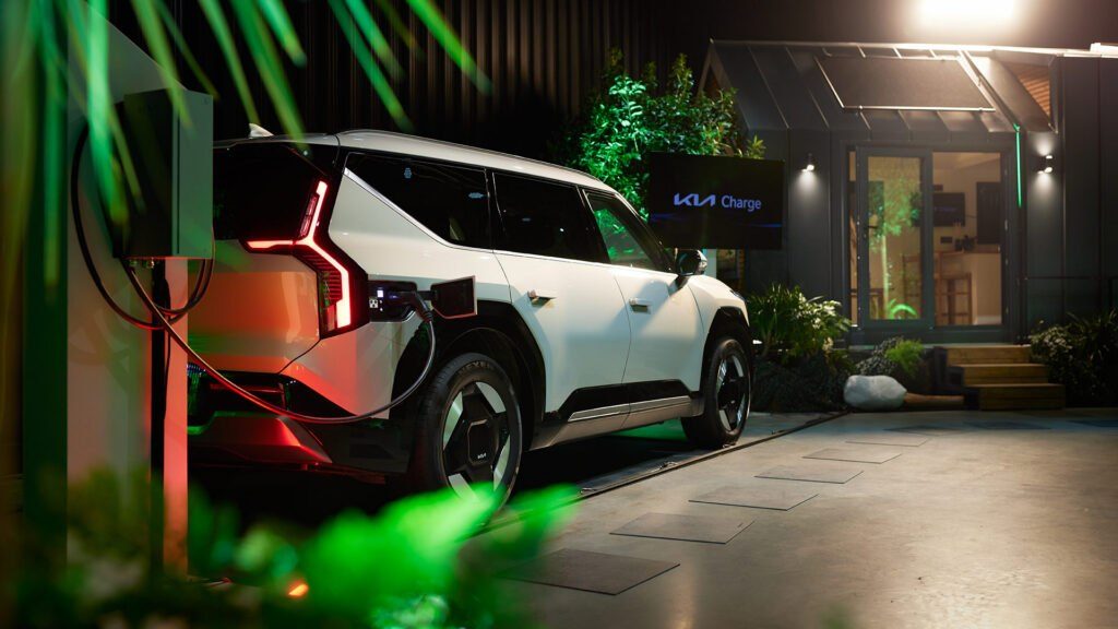 Kia EV9 s nachts aan de wallbox bij een woning