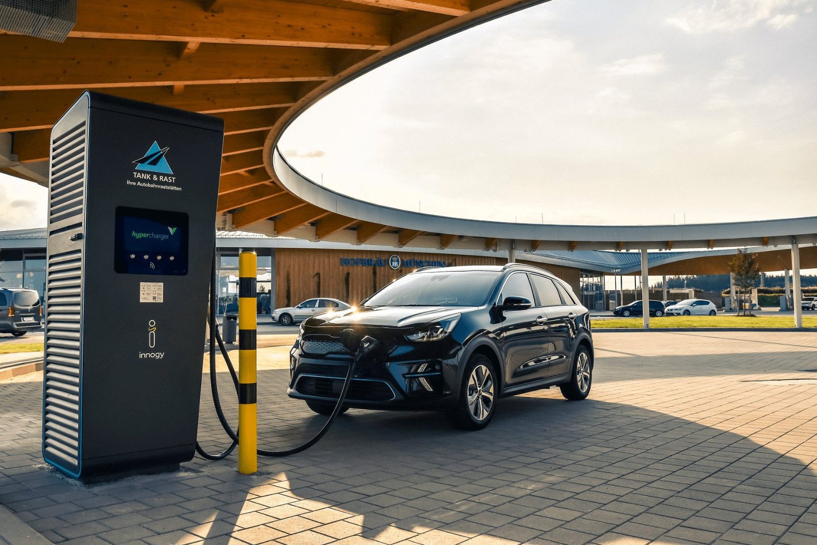 Kia Niro EV aan een snellader bij zonsondergang