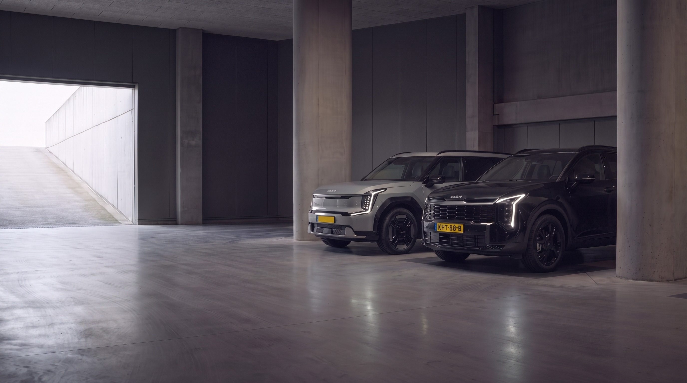 Kia Sportage en een elektrische Kia geparkeerd in een parkeergarage